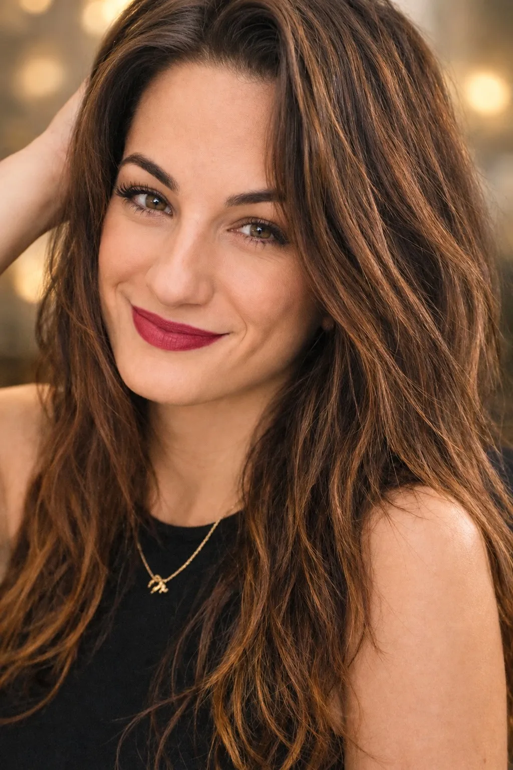 Portrait souriant de Sharon, longs cheveux bruns, en haut noir